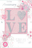 This anniversary card offers a soft, intimate celebration of long-lasting romance, its design unfolding with the same gentle charm as a pastel bouquet prepared for delivery across Grays. The palette blends tender pinks with silvery greys and clean whites, creating a calm, romantic atmosphere. At the card's centre, the word LOVE is rendered in softly raised glitter, the texture velvety and inviting to the touch. The O is replaced by a shimmering silver heart, its slightly embossed surface catching and reflecting the light, like a small polished charm resting on a bed of petals. Around this central emblem, blossoms in blush, mauve, and pale ivory unfurl in delicate, almost watercolour strokes, their edges softly blurred yet outlined with fine, precise lines that mirror the attention to detail of a skilled florist composing an anniversary bouquet. Tiny decorative touches-loose petals, curling swirls, and miniature butterflies-flutter throughout the design, adding a sense of playful movement, as though a light spring breeze were drifting through a garden near Grays Town Park. Elegant script phrases, including On Our Anniversary and I love you today and always, are placed thoughtfully within the artwork, their graceful, flowing letters echoing the curves of the vines and stems. The composition feels tender and reflective, ideal for marking a shared journey, and would pair beautifully with fresh anniversary flowers delivered by Flower Delivery Grays, together creating a keepsake moment that is soft-spoken yet profoundly heartfelt.